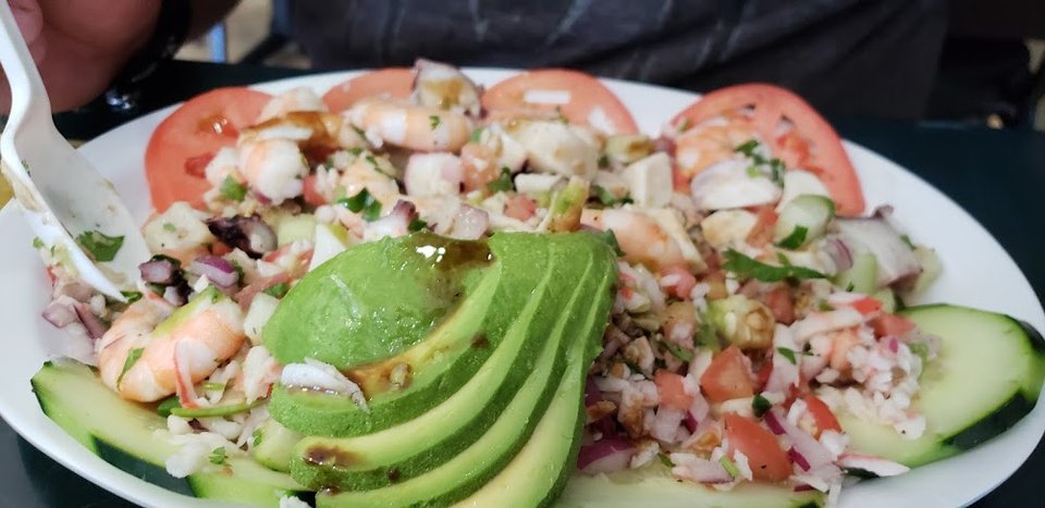 Printed menu with seafood tacos and tostadas.