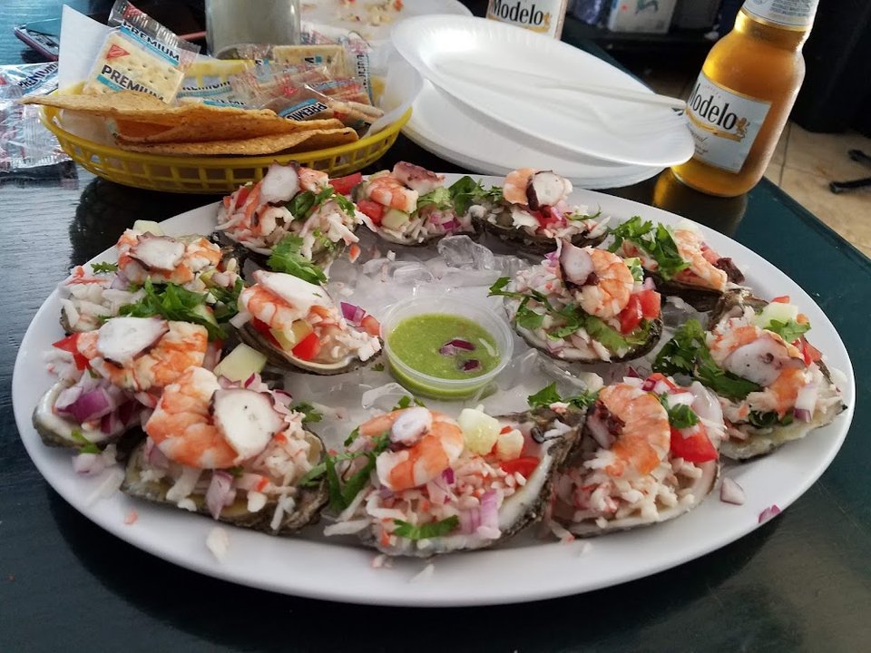 Printed menu with seafood tacos and tostadas.